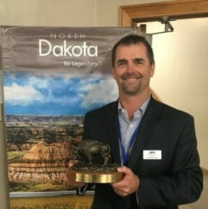 DCN Director of Sales Todd Domres holding the Bison Award. Domres represented DCN on the K-20W Initiative Team.